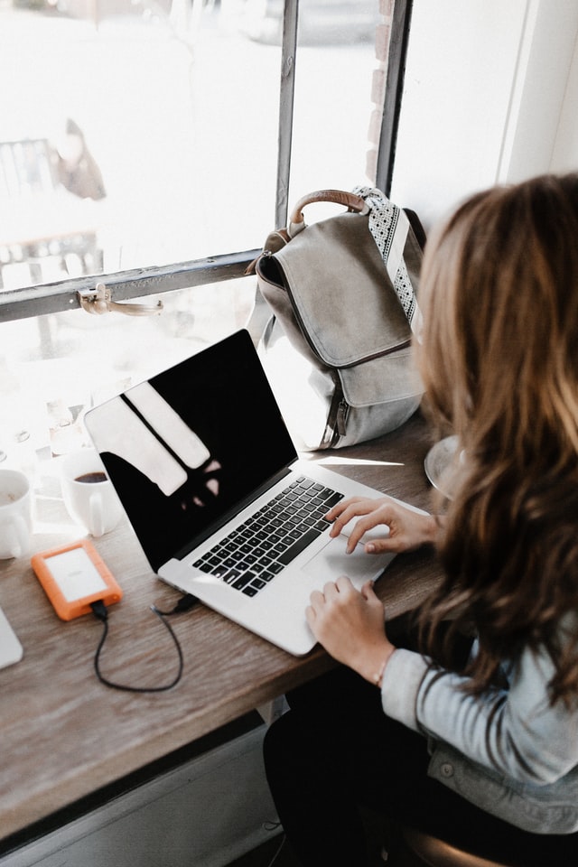 Cybersecurity professional working remotely at laptop in a cafe