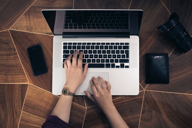 Birdseye of cybersecurity professional's hands working on laptop